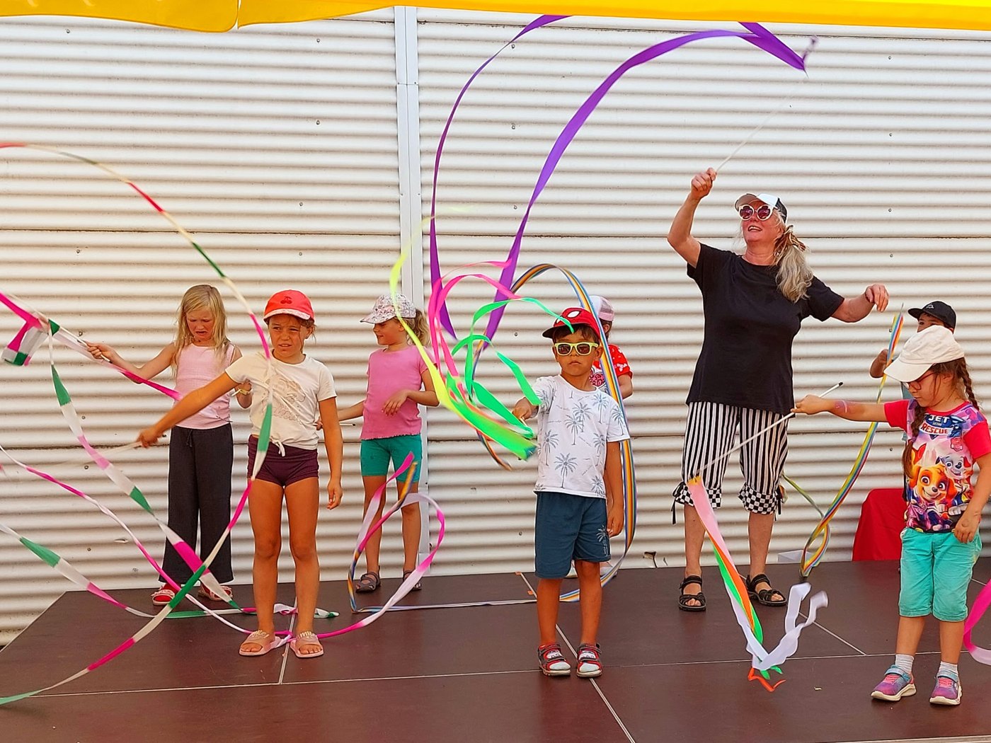 Zauber-Zirkus: Kinder tanzen mit bunten Bändern auf der Bühne