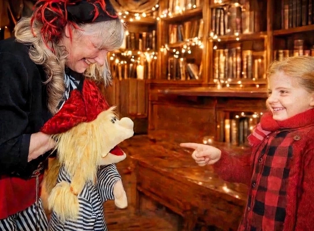 Andrea Hardy mit Lilou und ein Mädchen zeigt auf die Puppe