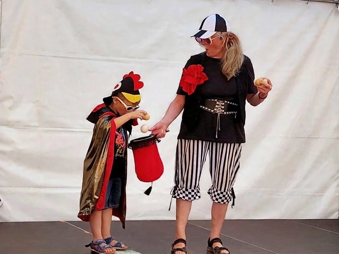 Zauberclown MAXI mit einem Kind im Hühnerkostüm und Zauberhut