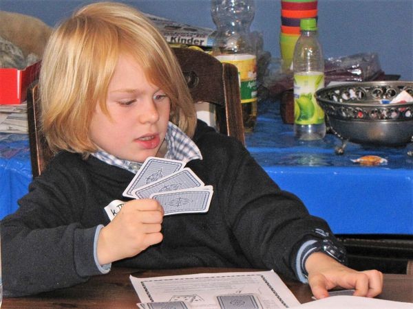 Junge übt Kartentricks im Zauberunterricht