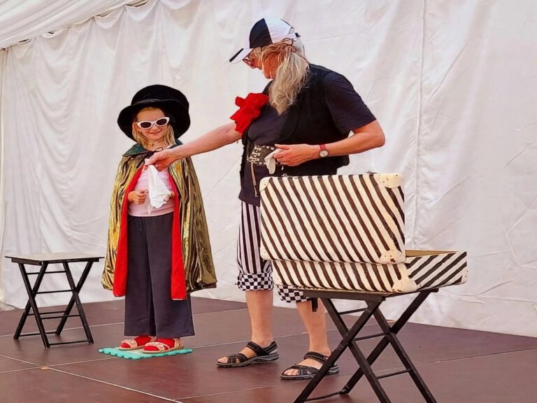 Zauberclown MAXI mit einer Zauberschülerin auf der Bühne
